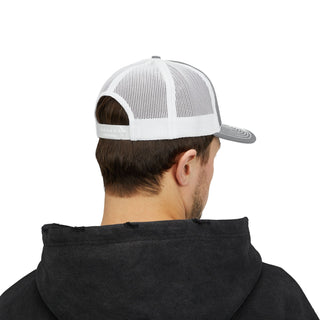 A young man wearing a grey and white trucker hat, viewed from behind, with a black hoodie visible in the foreground.
