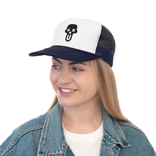 A woman wearing a denim jacket and a white and navy trucker cap with a UNFLTRD logo.