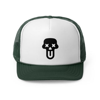 A green and white trucker hat featuring a bold black skull graphic with stars for eyes and a tongue sticking out.