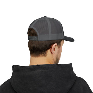 A young man in a black hoodie, viewed from behind, wears a grey trucker cap with mesh panels and a curved brim.
