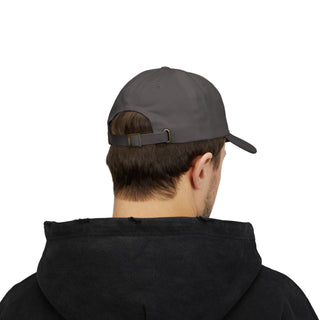 A young man wearing a dark graphic hat and a black graphic hoodie, viewed from behind, showcasing the cap's adjustable strap.