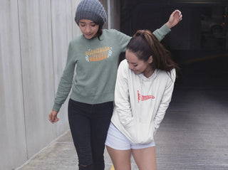 Two girlfriends in UNFLTRD crewneck sweat shirt and pullover hoodie having fun in the city